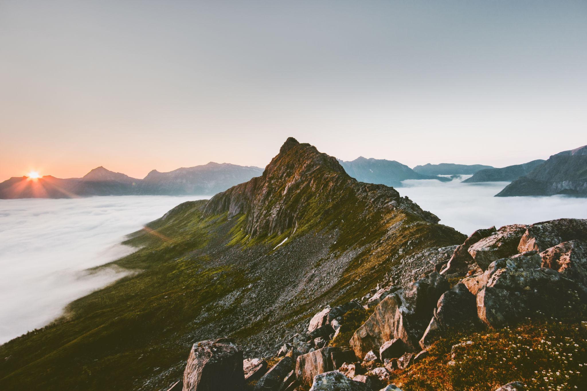 Mountain peak with clouds below sunrise